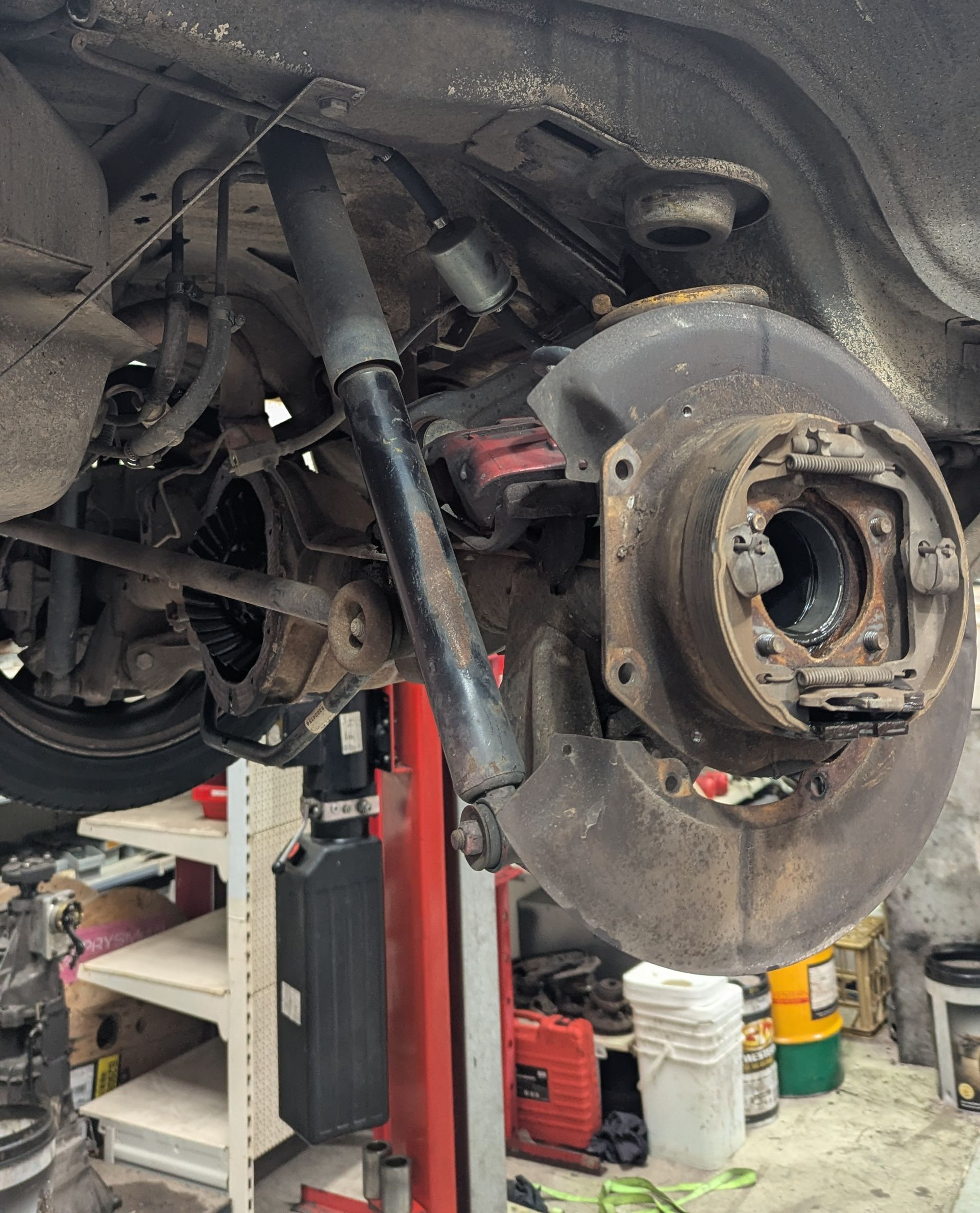 Rear car suspension being worked on in a garage. Shock absorber, brake components, and axle are visible  — ATD Automotive in North Wollongong, NSW