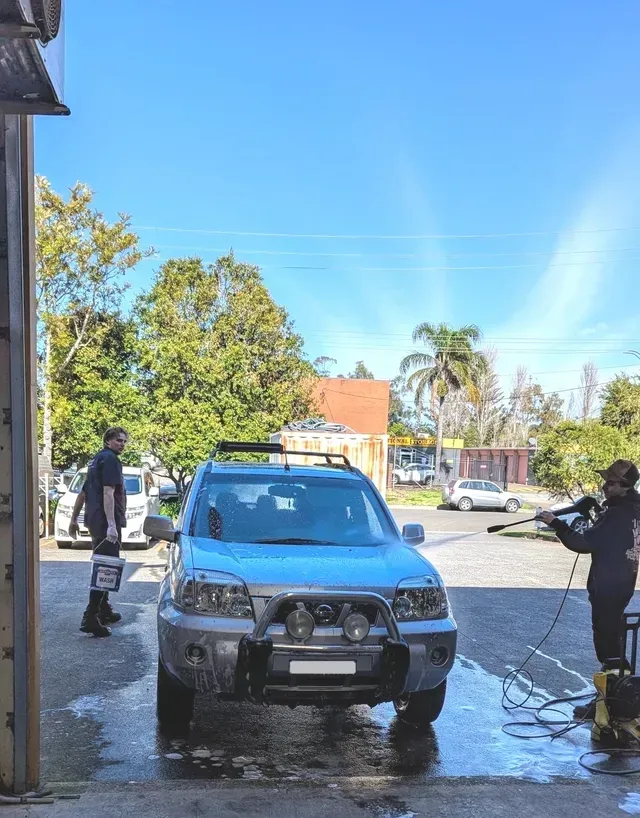 Two People Washing a Silver SUV at A Car Wash on A Sunny Day — ATD Automotive in North Wollongong, NSW