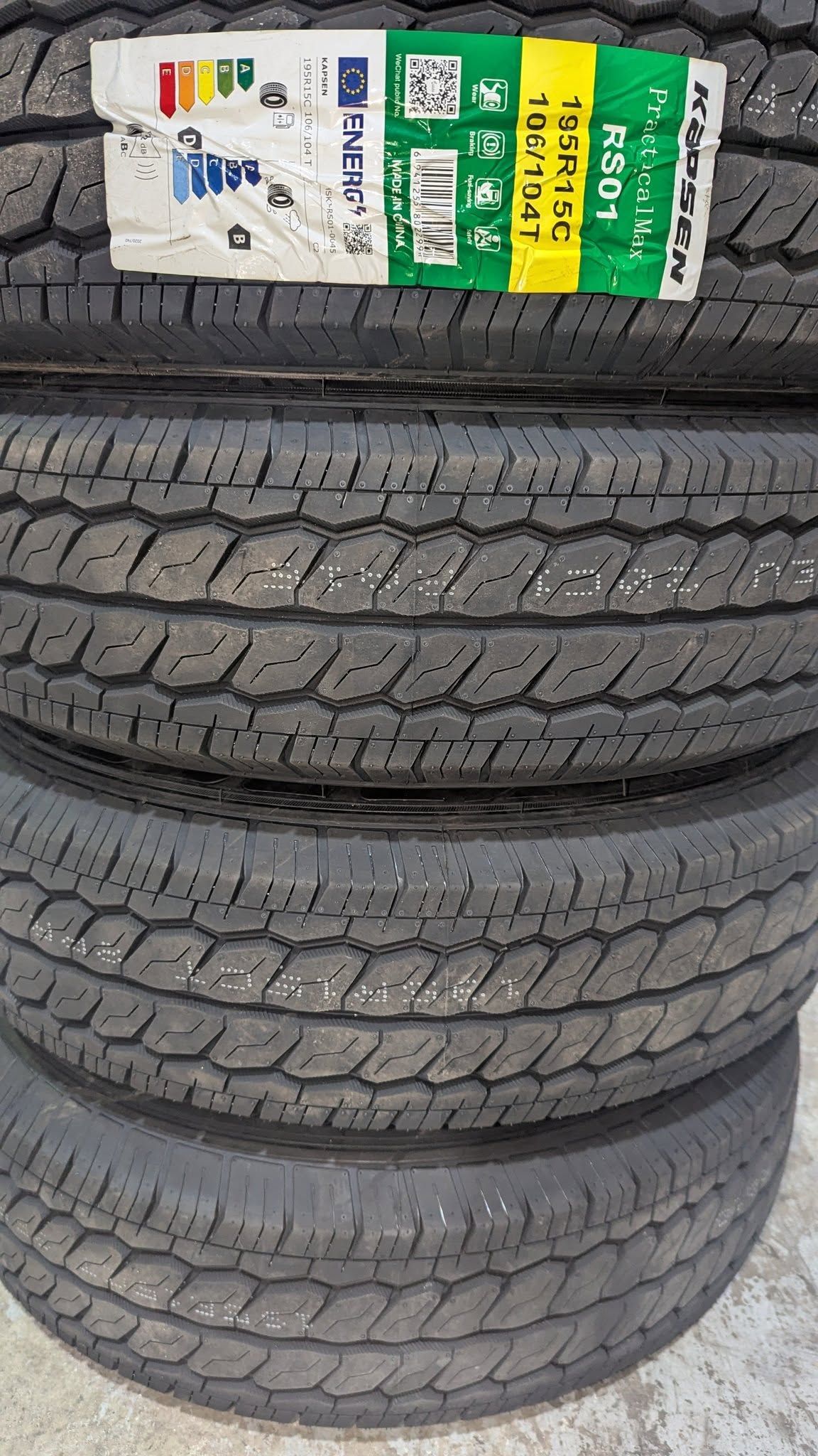 Four New Black Tires Stacked Vertically with A Label on The Top Tire — ATD Automotive in North Wollongong, NSW