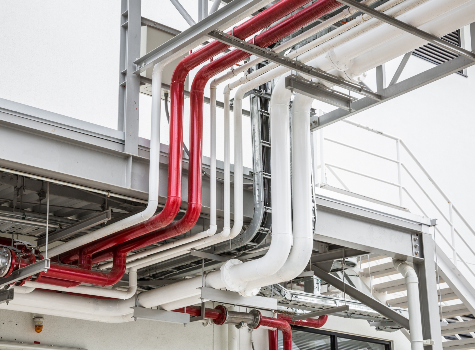 A bunch of pipes are hanging from the ceiling of a building.