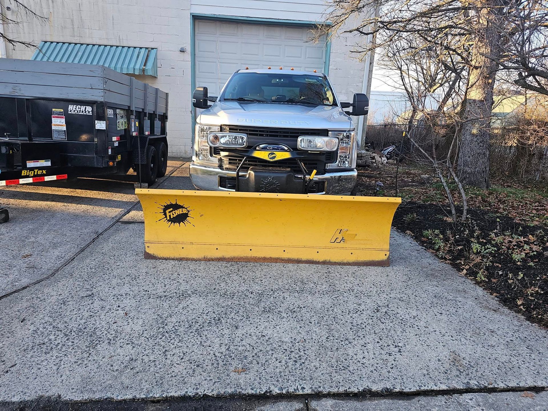A snow plow is parked in front of a building.