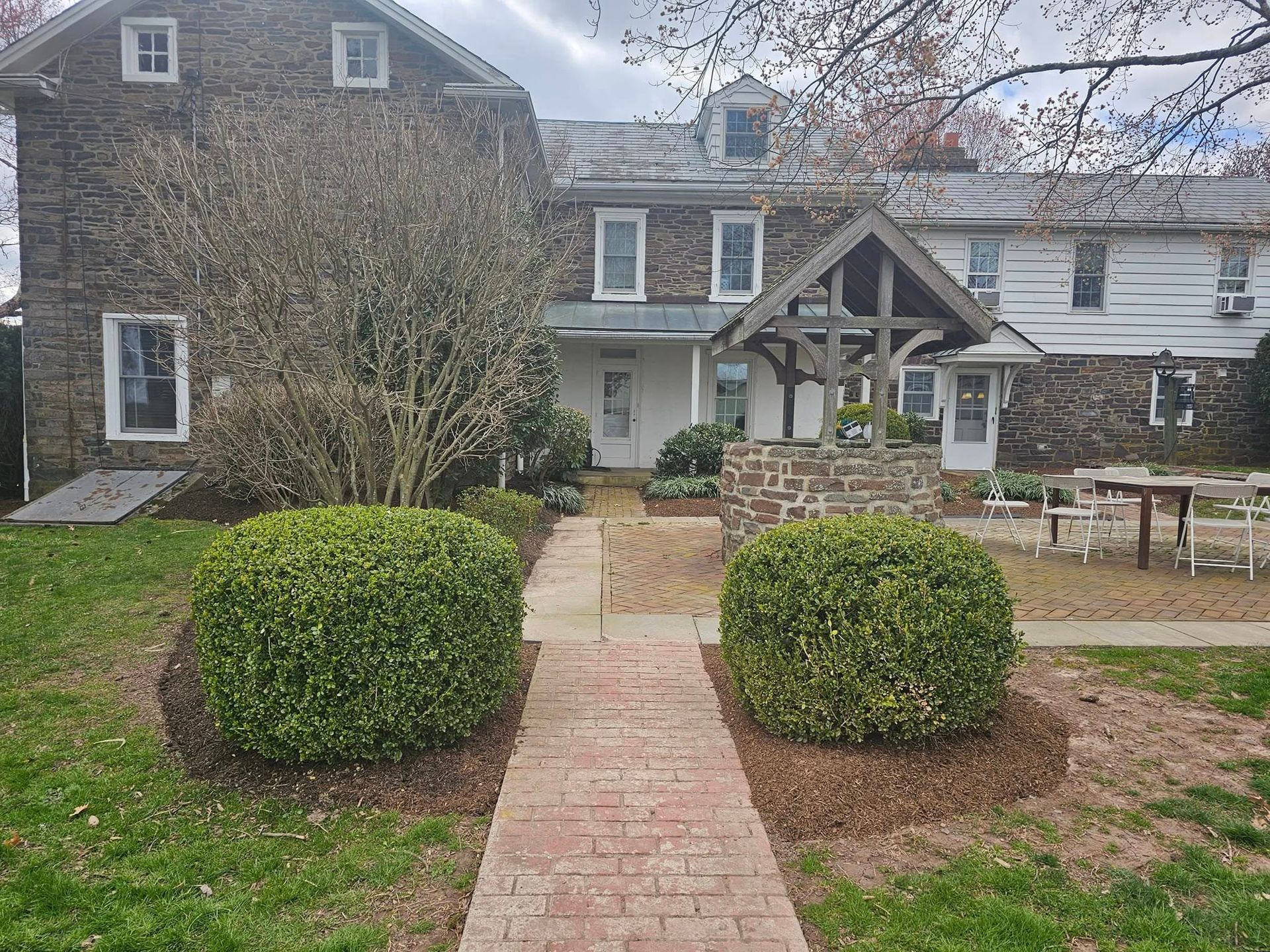 A large stone house with a brick walkway leading to it.