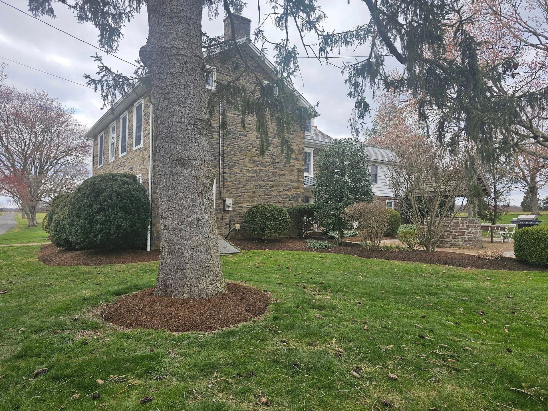 A large stone house with a large tree in front of it.
