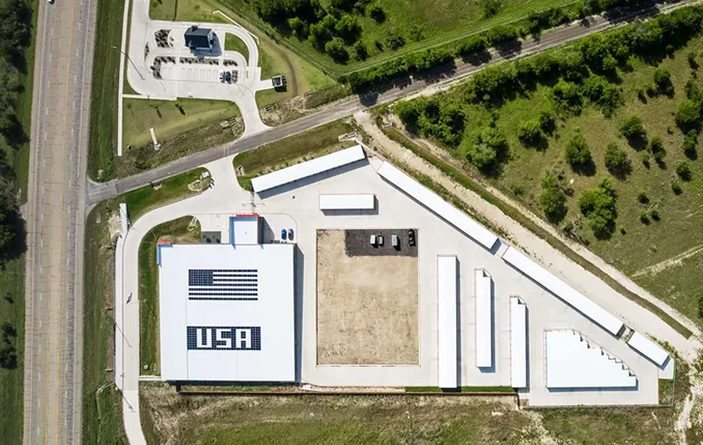 Aerial view of a self-storage facility with a large American flag and the text "USA" on the main building roof.