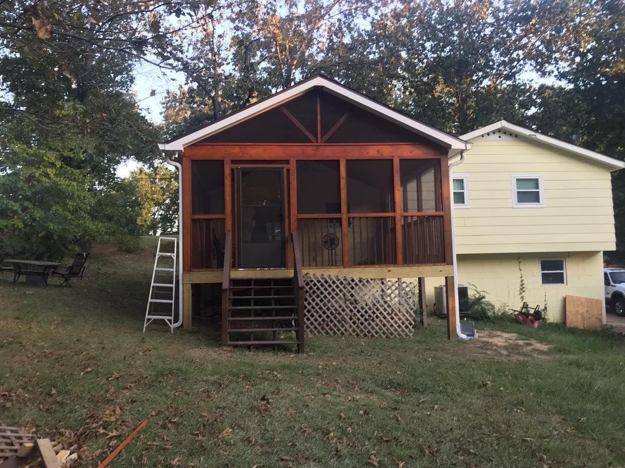 A screened in porch is being built on the side of a house.