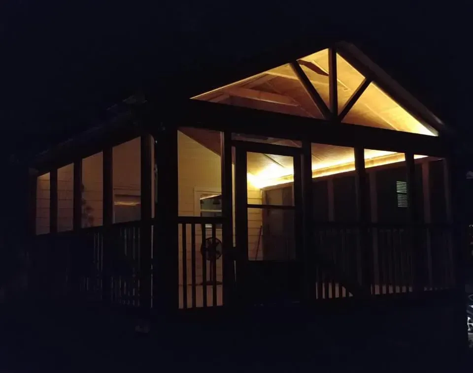 A screened in porch is lit up at night