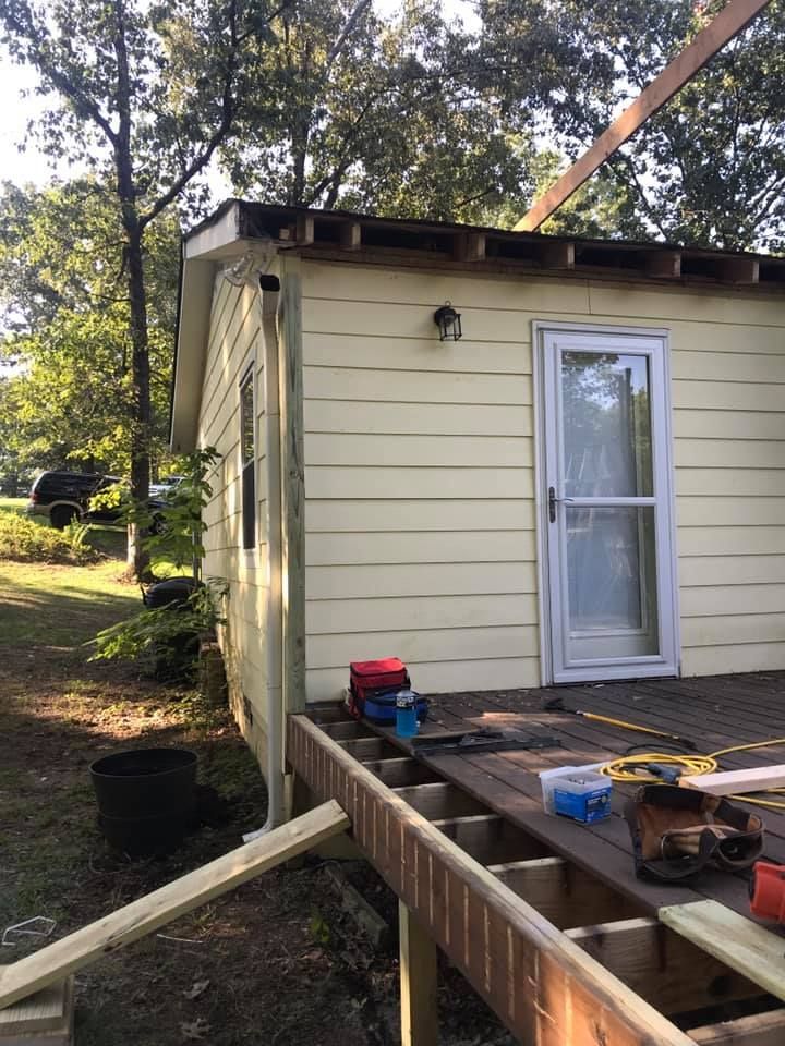 A small house is being built with a wooden deck in front of it.