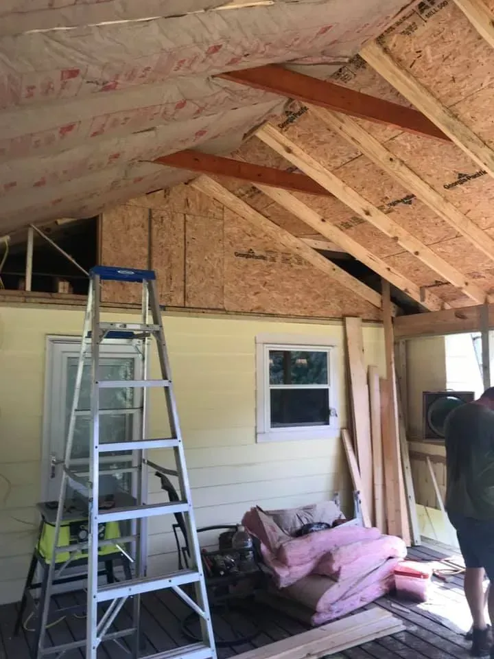 A man is standing in a room with a ladder.