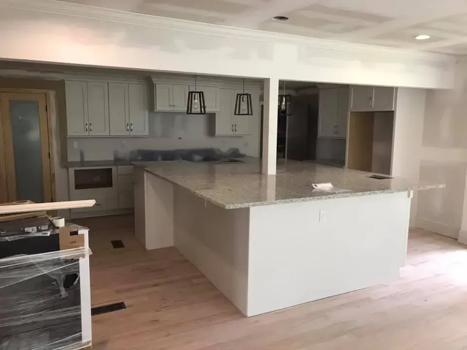 A kitchen with white cabinets and granite counter tops is being remodeled.