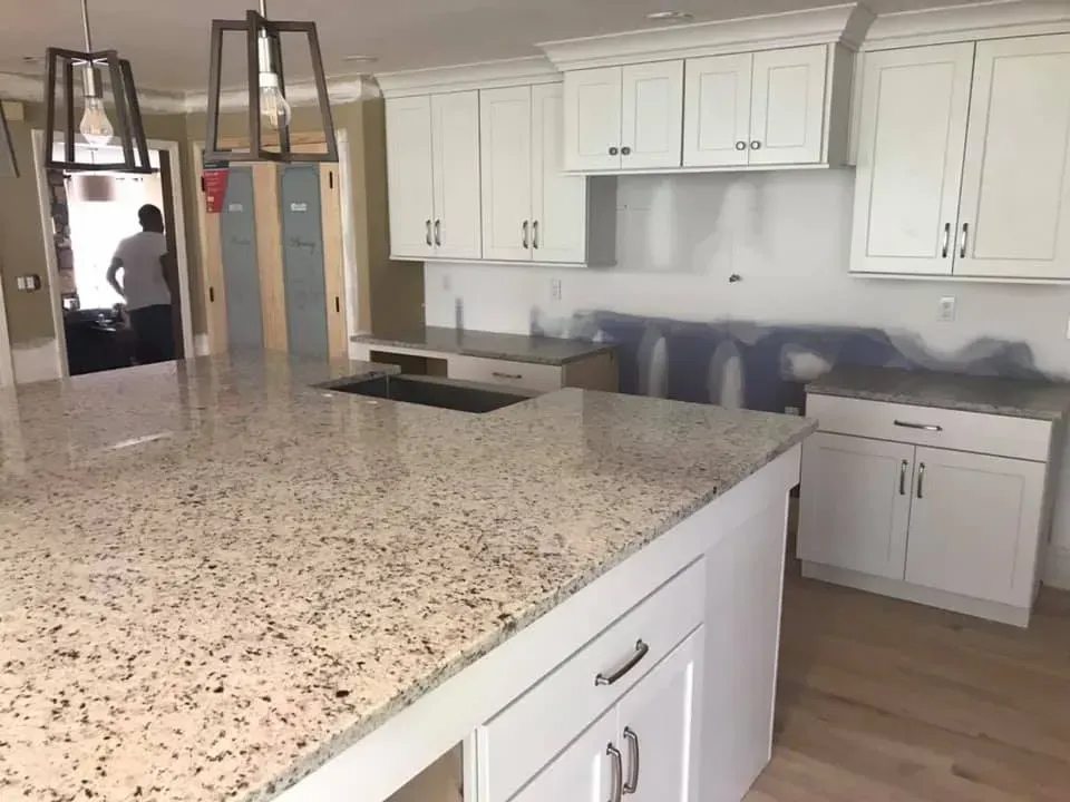 A kitchen with white cabinets and granite counter tops
