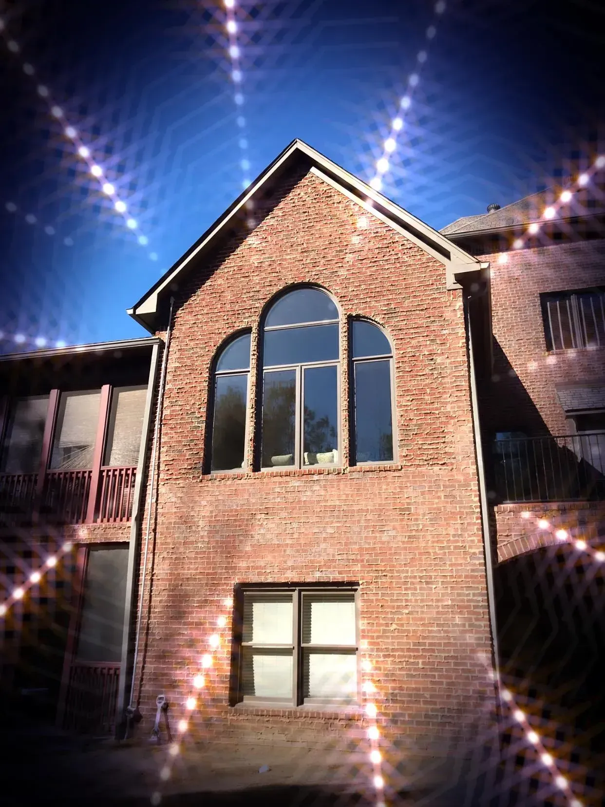 A brick building with arched windows and a blue sky in the background