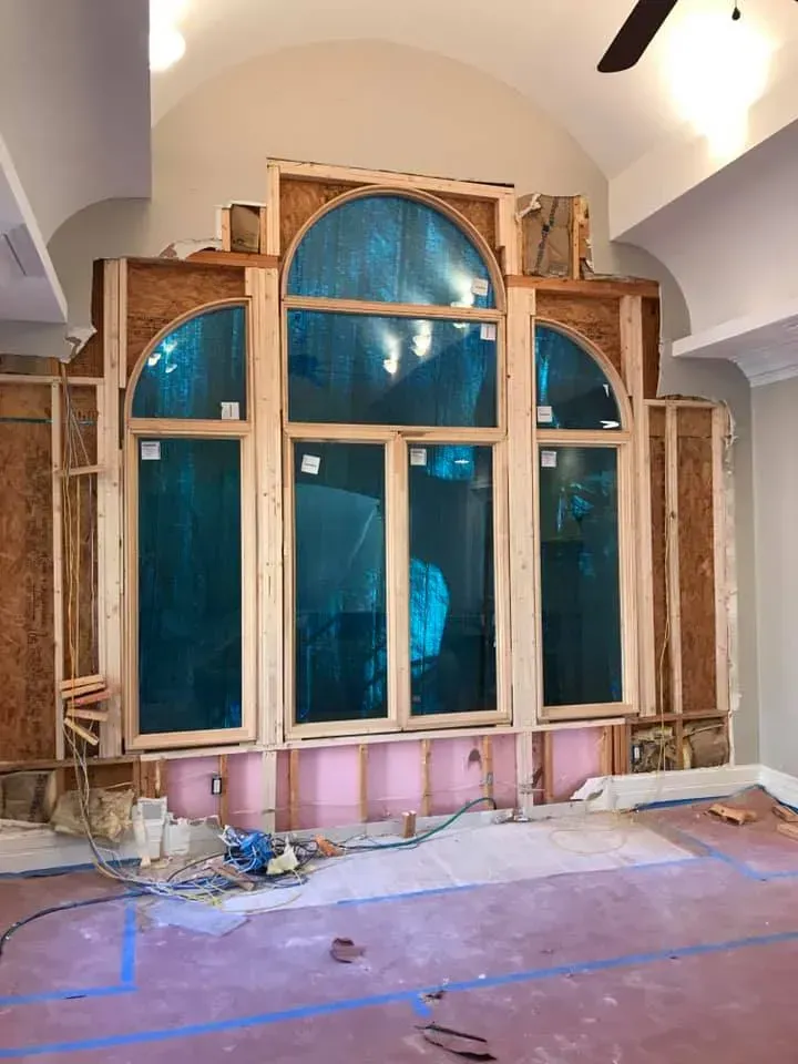 A room with a lot of windows and a ceiling fan.