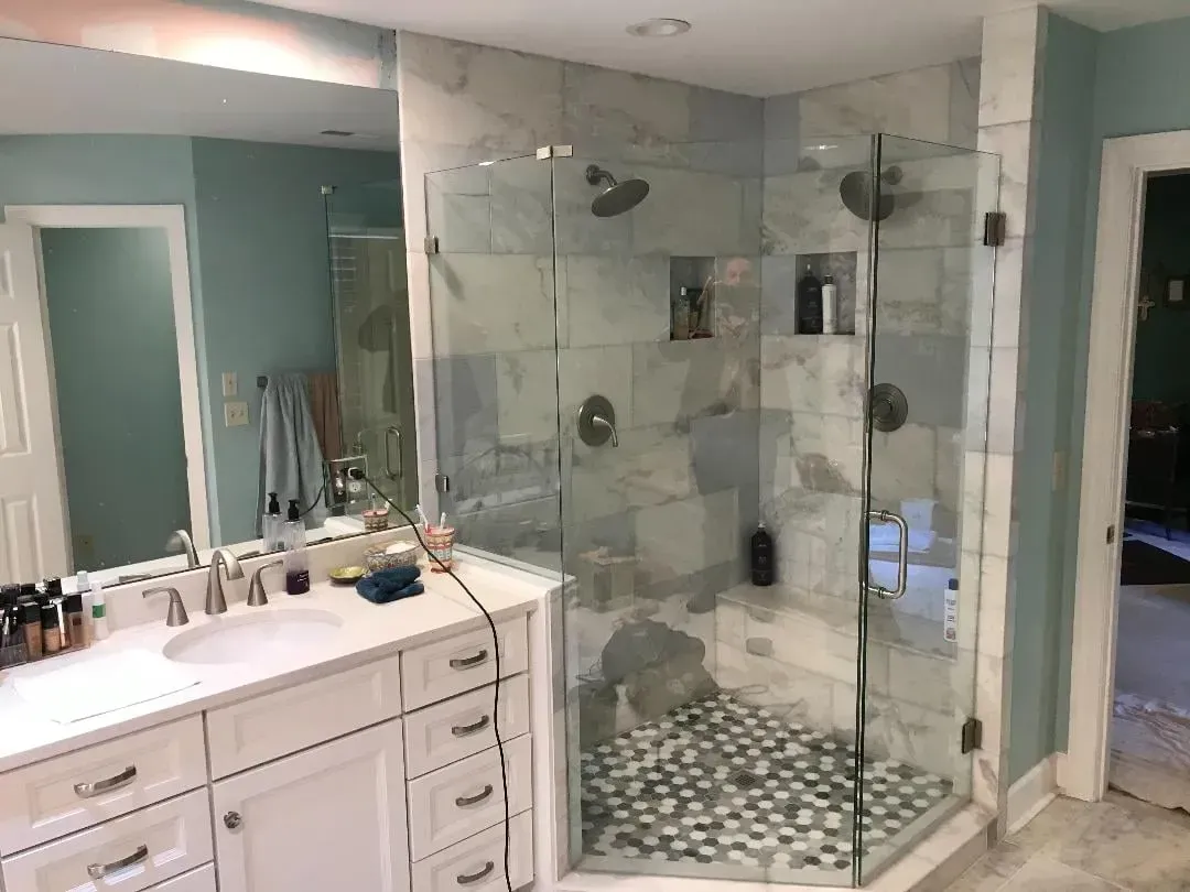 A bathroom with a walk in shower and a sink.