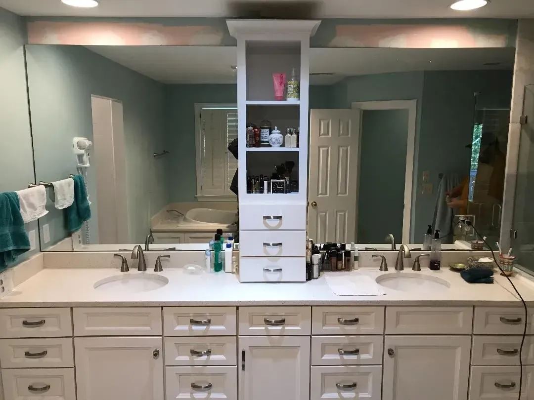 A bathroom with two sinks and a large mirror.