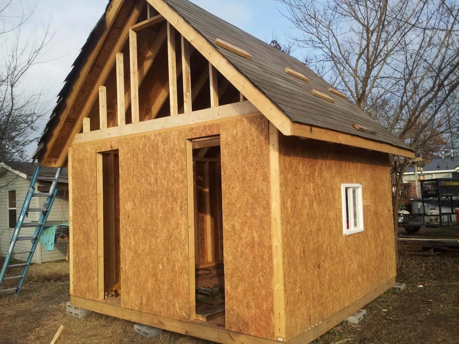 A small wooden house with a roof and a window