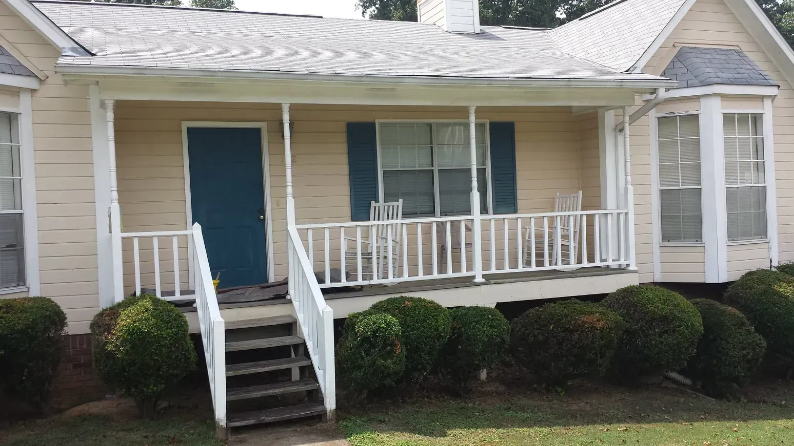 A small house with a porch and stairs