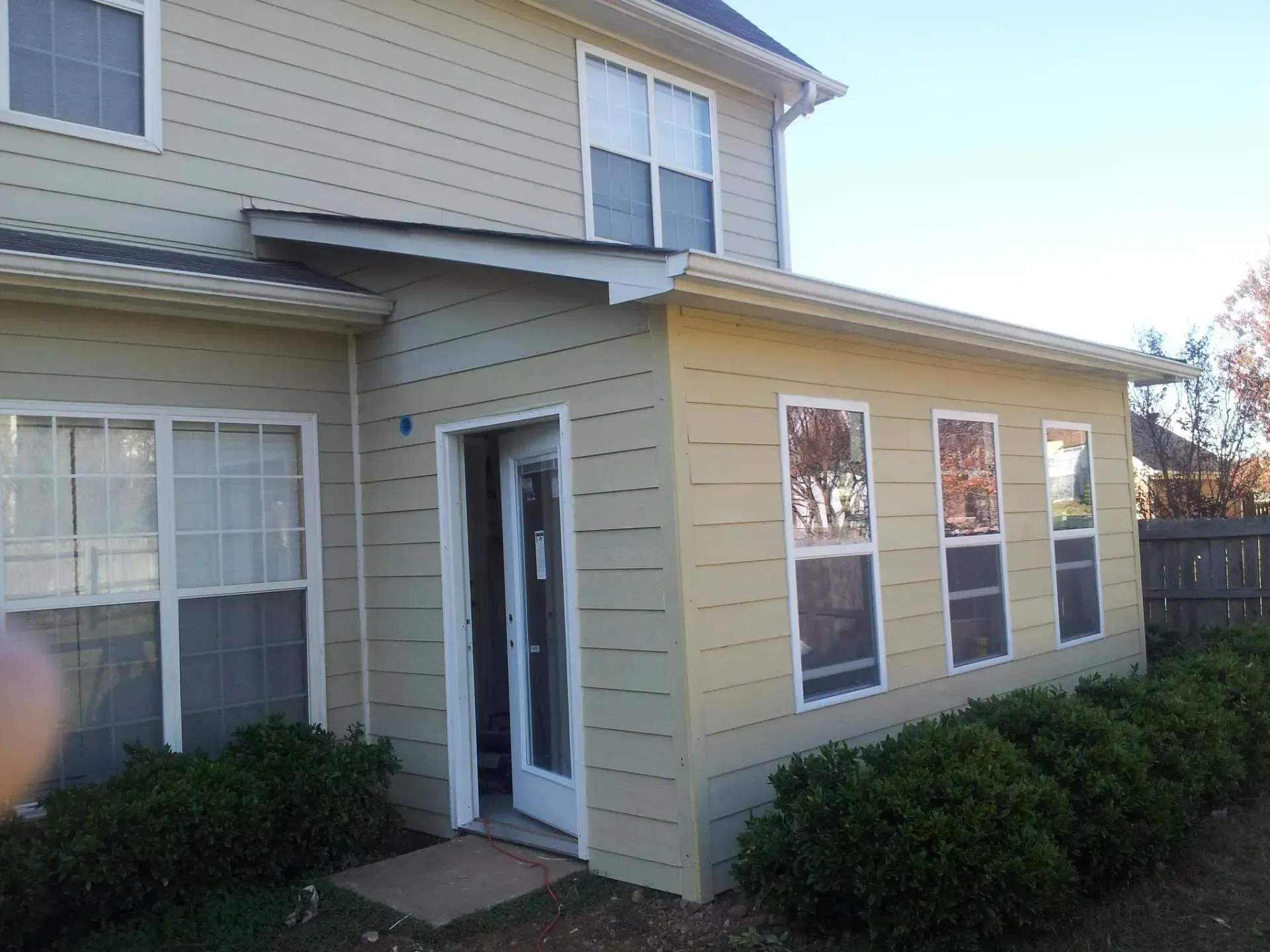 A house with a sliding glass door and many windows