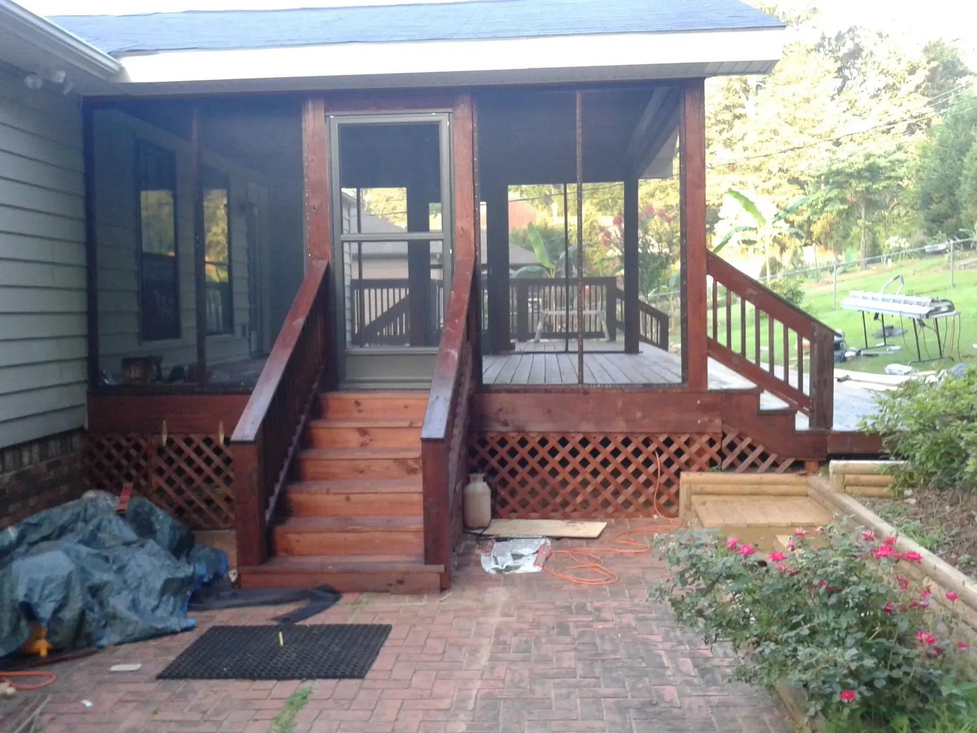 A ladder is sitting on a wooden deck in front of a house under construction.