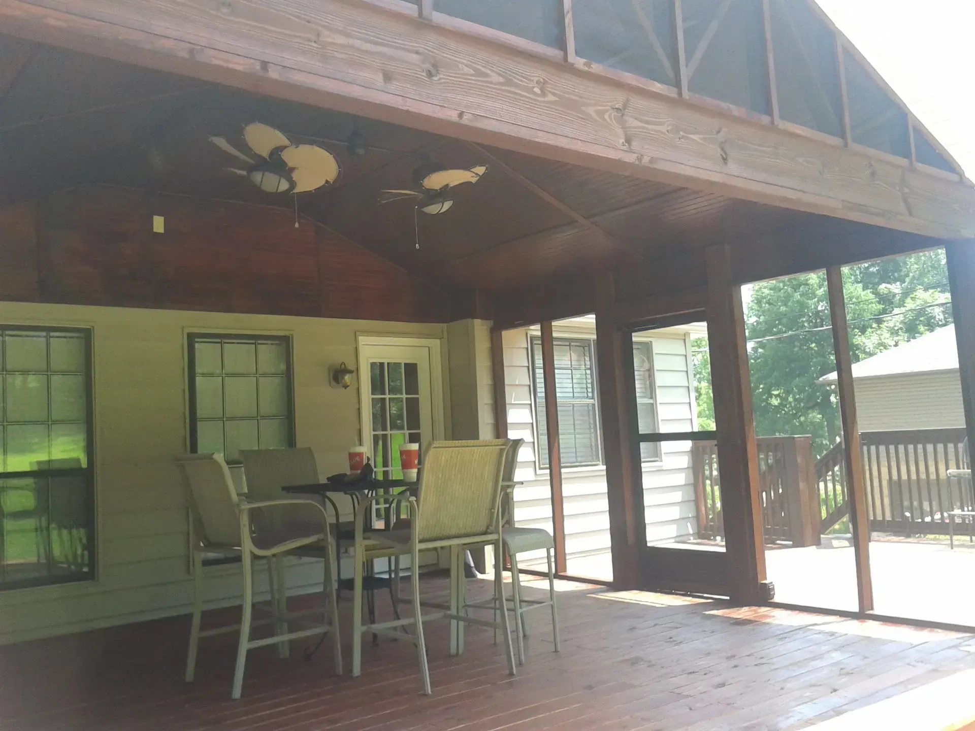 A screened in porch with a table and chairs