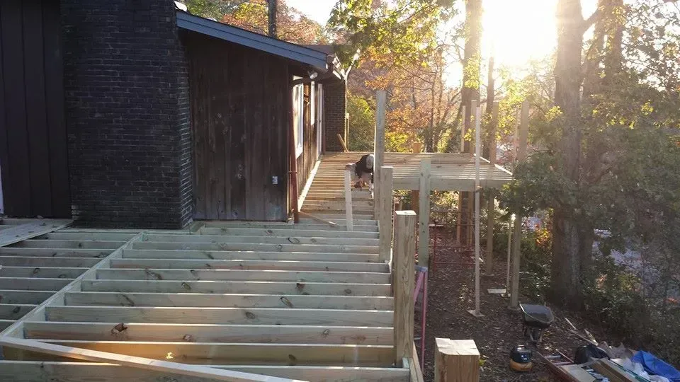 A wooden deck is being built in front of a house.