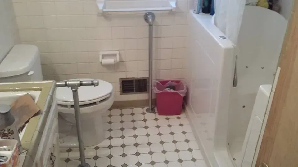 A bathroom with a toilet , sink , and shower.