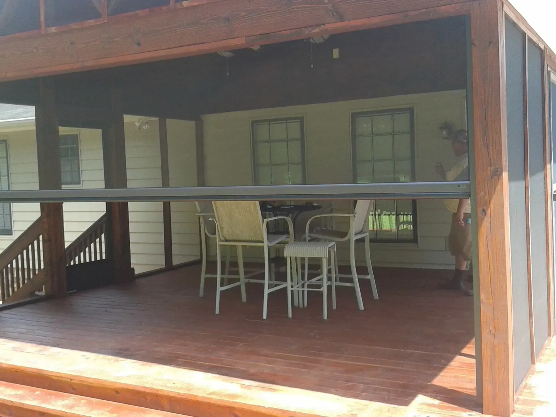 A screened in porch with a table and chairs on it