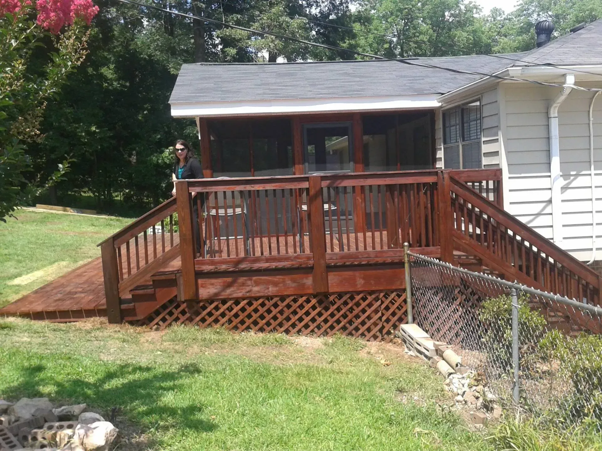 A house with a screened in porch and a wooden deck