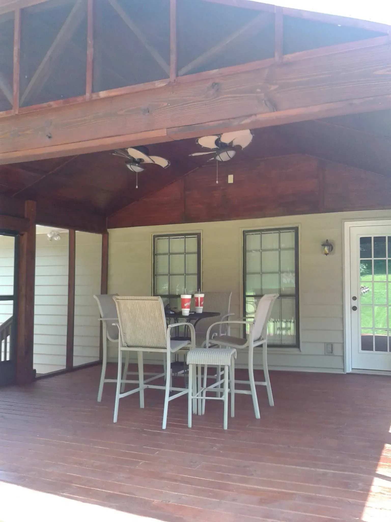 A screened in porch with a table and chairs