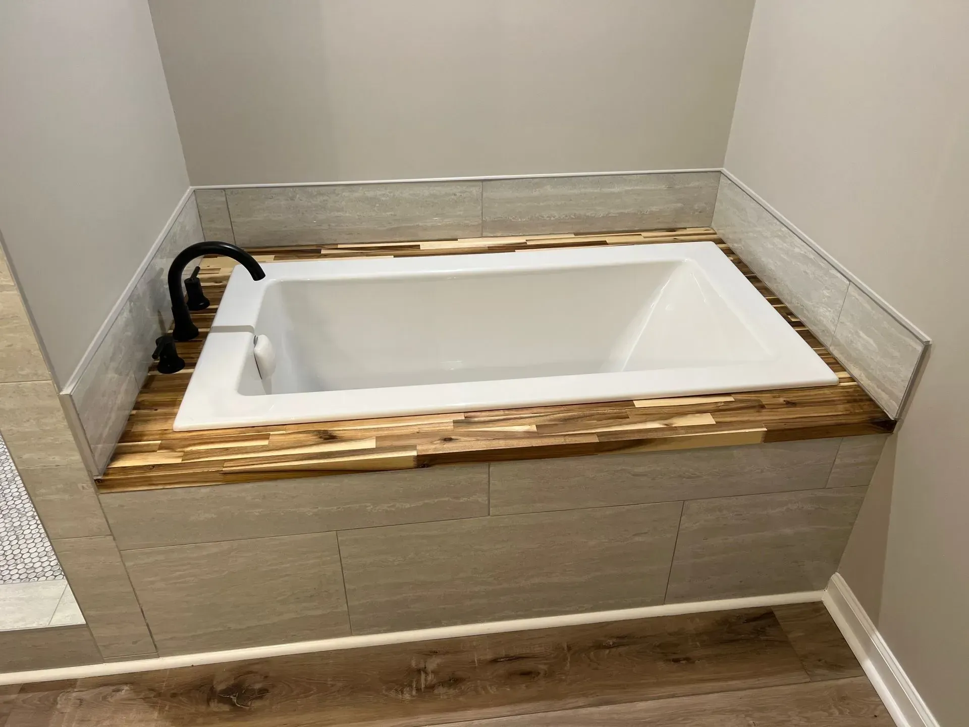 A bathtub is sitting on top of a wooden counter in a bathroom.