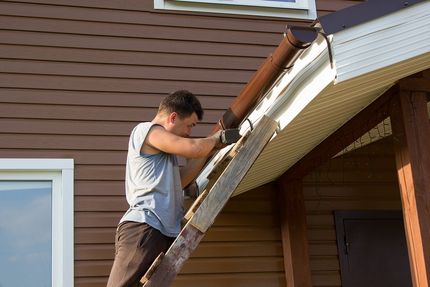 man installing roof gutter