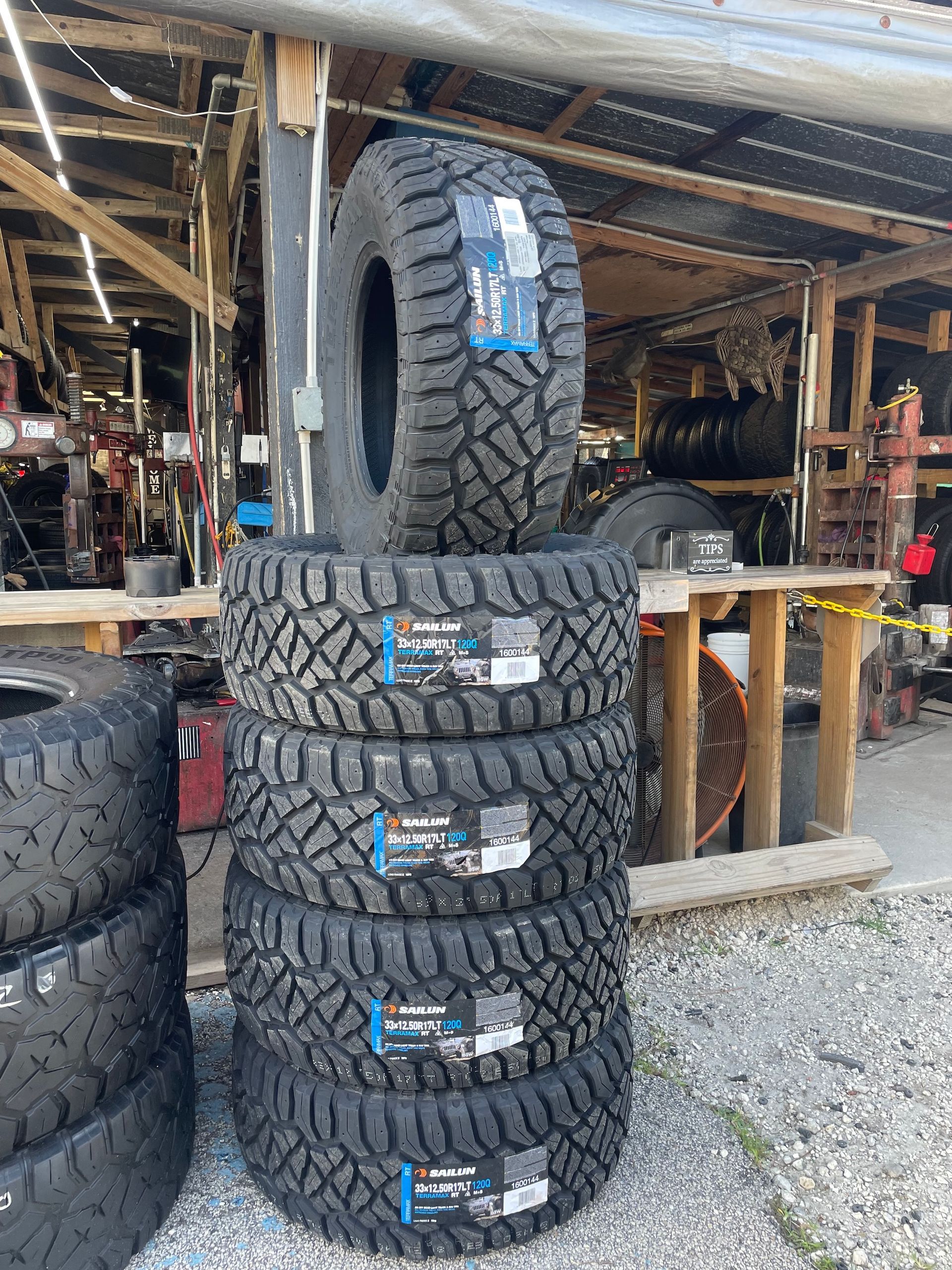 Brand new tire leaning against a clean shop wall