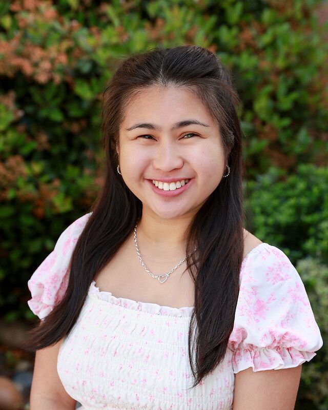 A woman wearing a striped shirt is smiling for the camera