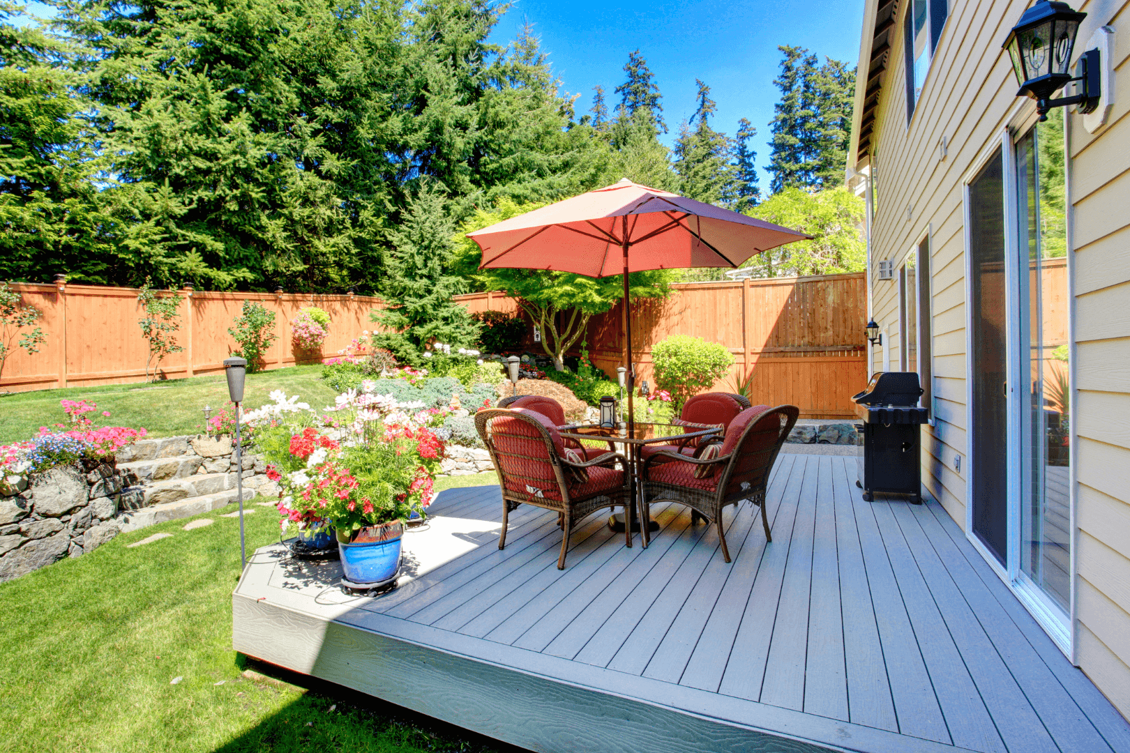 Construction worker kneeling, using a trowel to smooth concrete in a road joint, wearing orange vest and gloves.