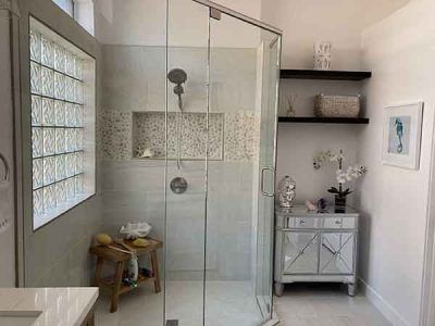 A bathroom with a walk in shower and a sink.