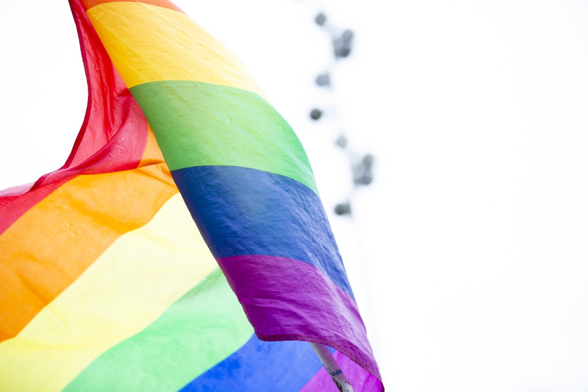 Rainbow Pride flag waving against a white background