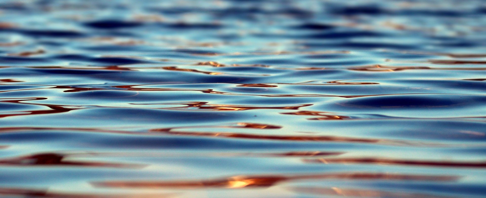 Rippling blue water with warm reflections of light