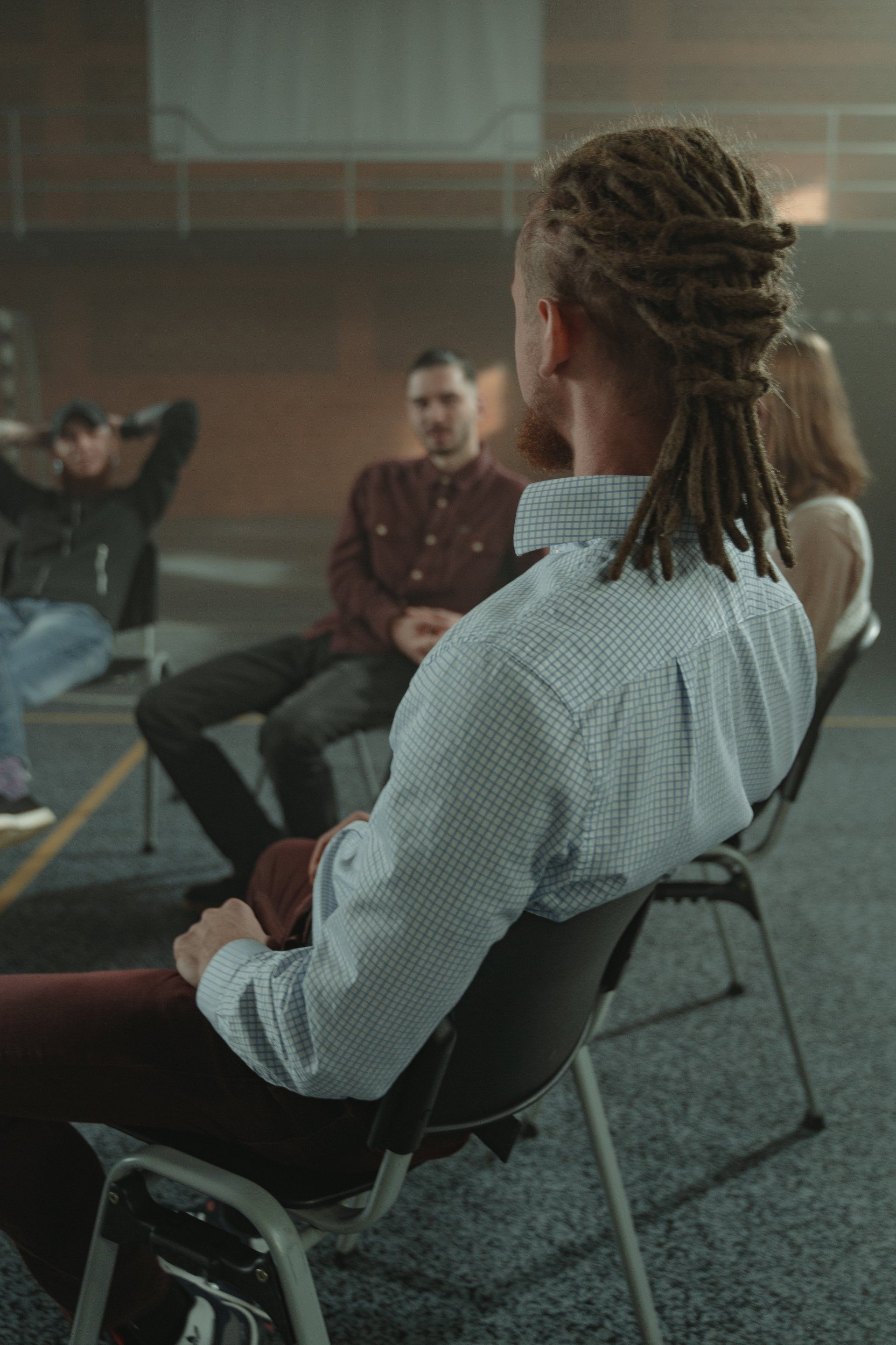 People seated in a circle during a group discussion in a room
