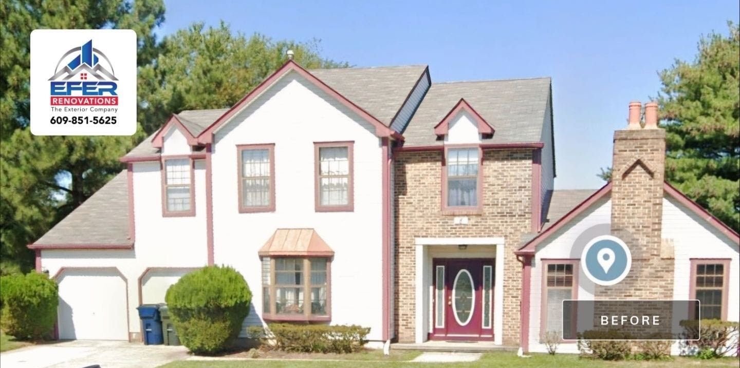 A large white house with a red door and a chimney