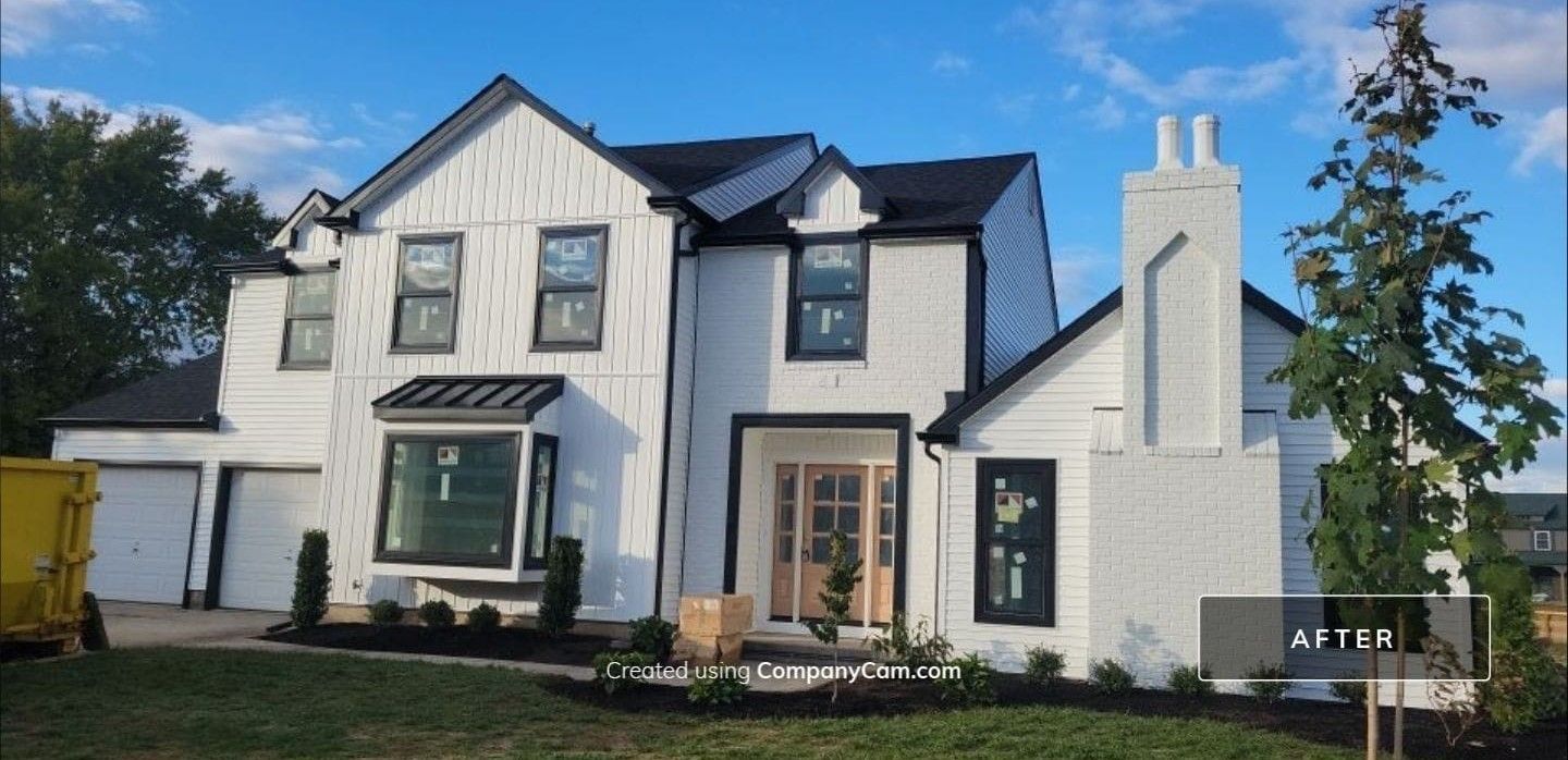 A large white house with black trim and a black roof