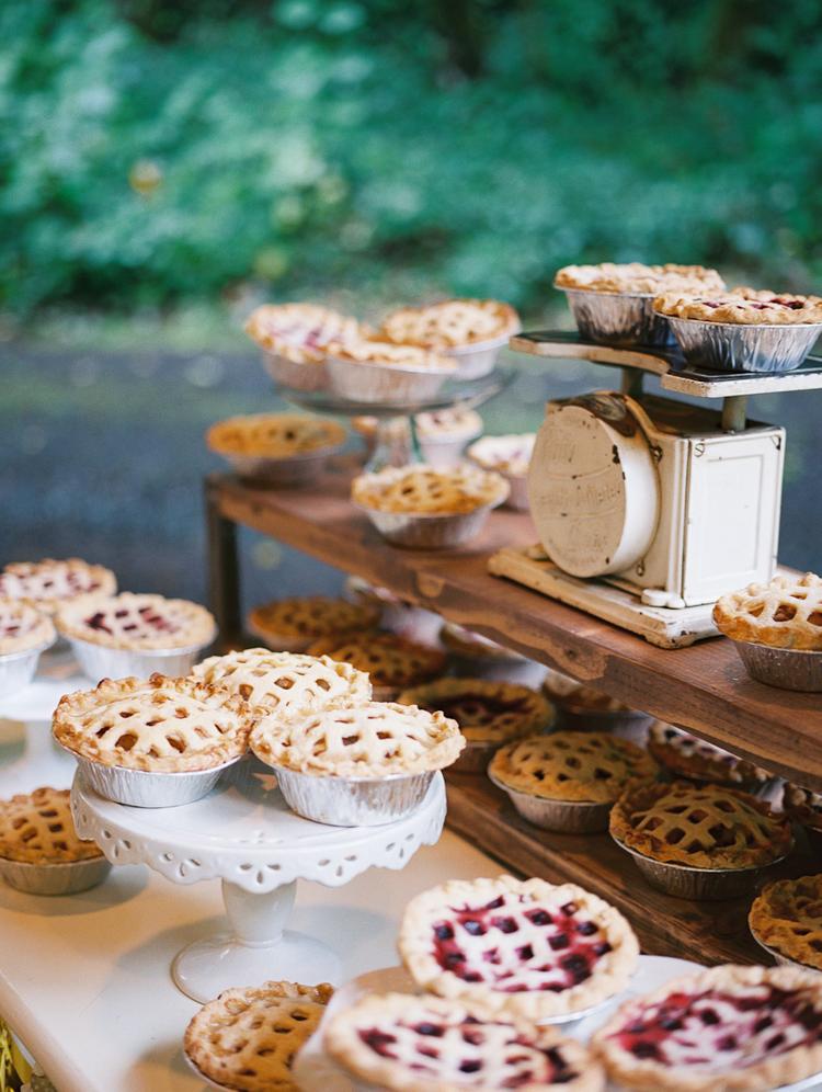 Dessert table at a wedding, covered in pies
