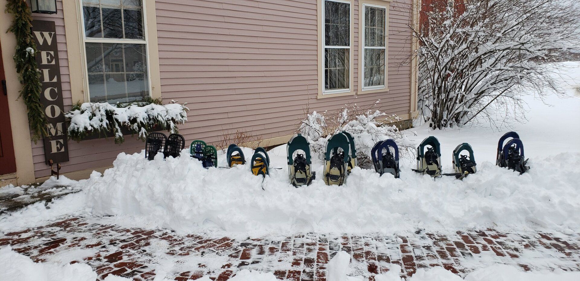 Snowshoes lined up in the snow outside of The Wildflower lobby