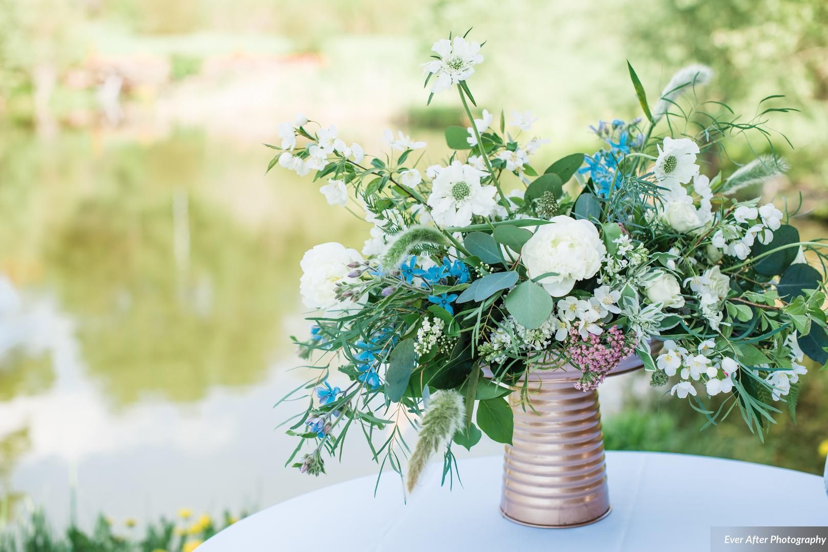 Hand made wedding bouquet with copper vase, peonies, and blue flowers.