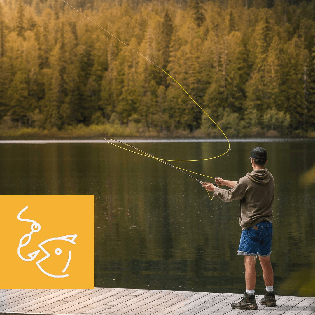 A man is standing on a dock fishing in a lake.