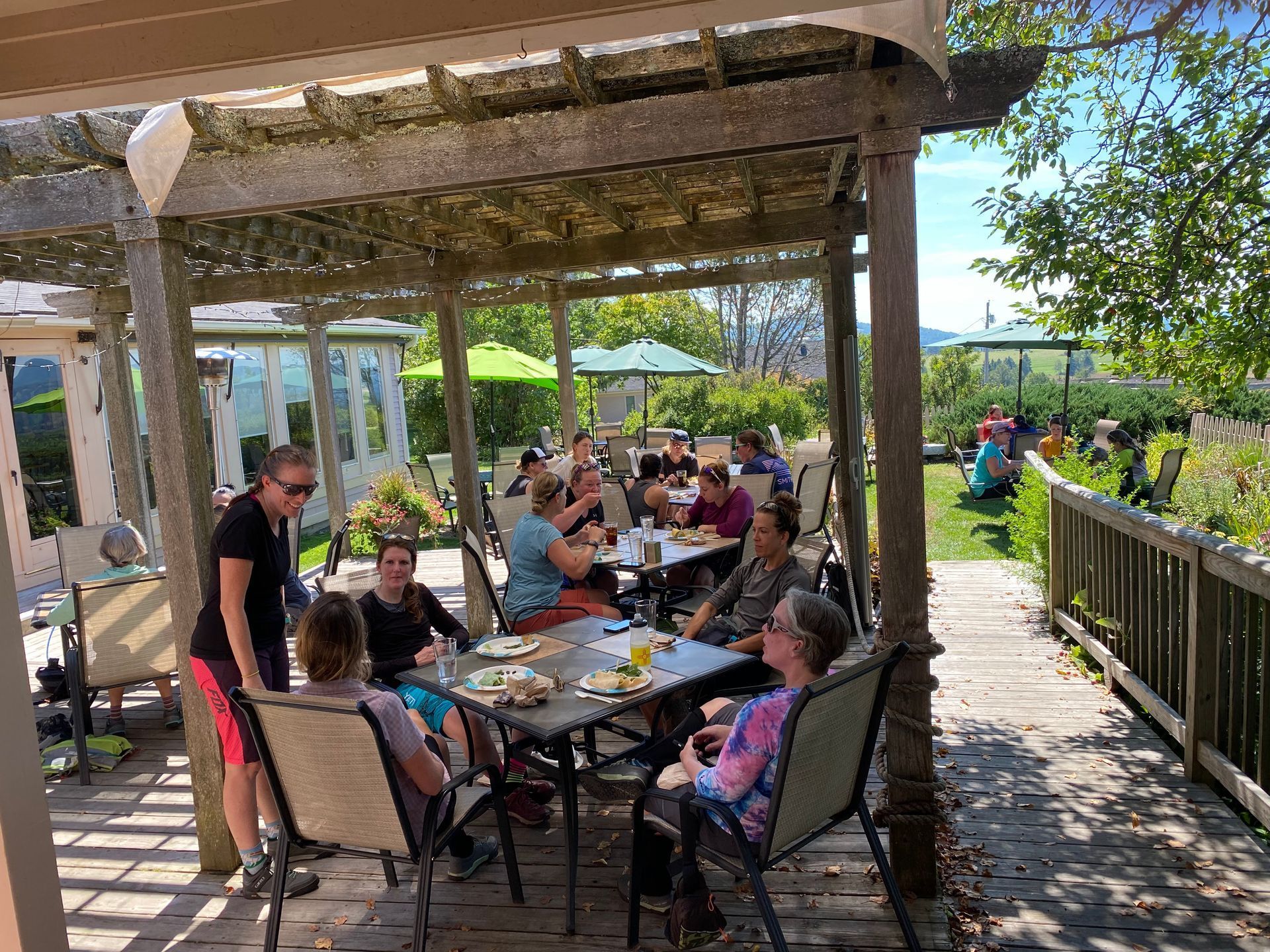 Several groups of people happily dine outdoors at The Wildflower Restaurant and Pub in Northern, VT
