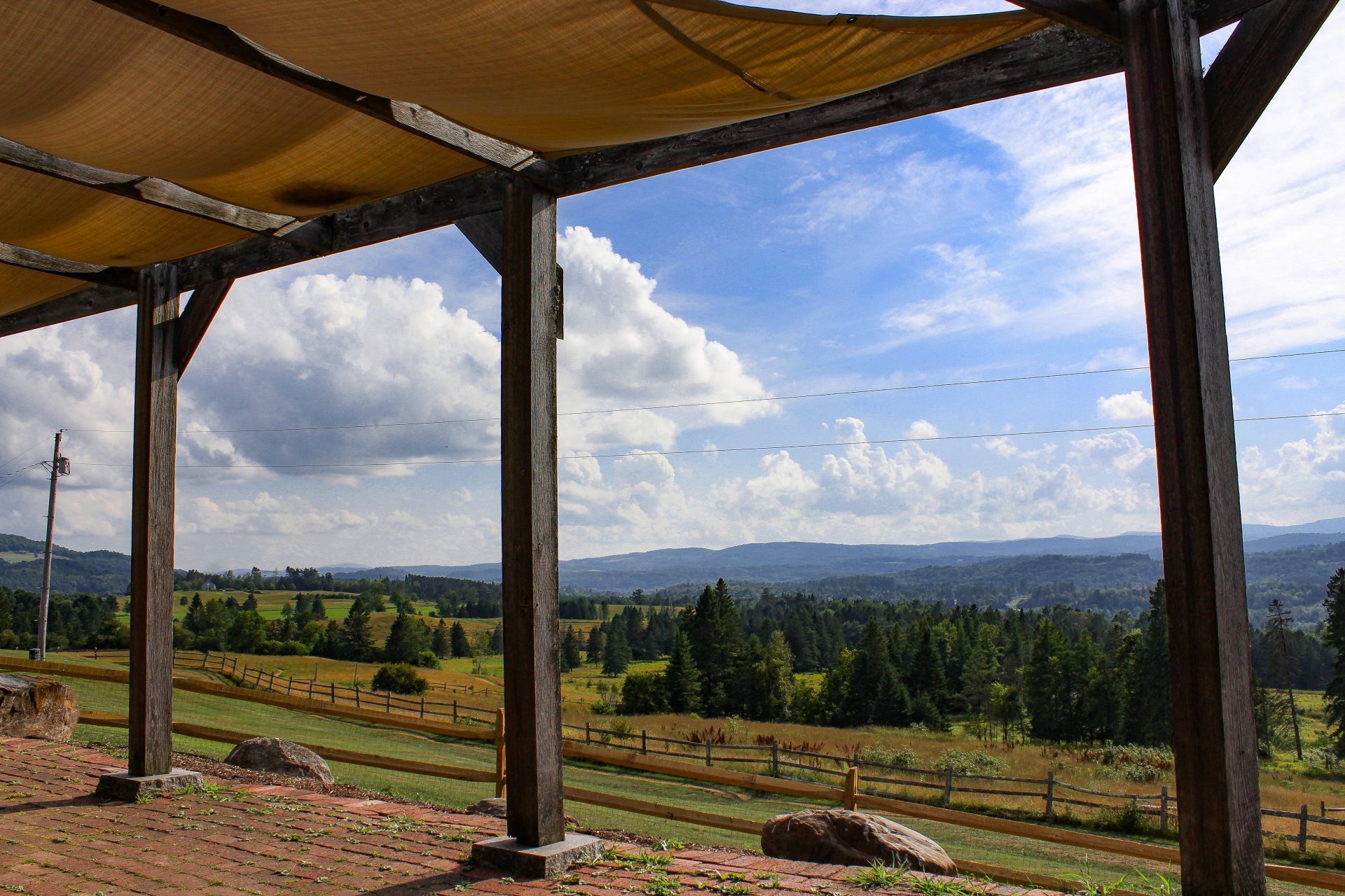 A pergola with a view of a field and mountains