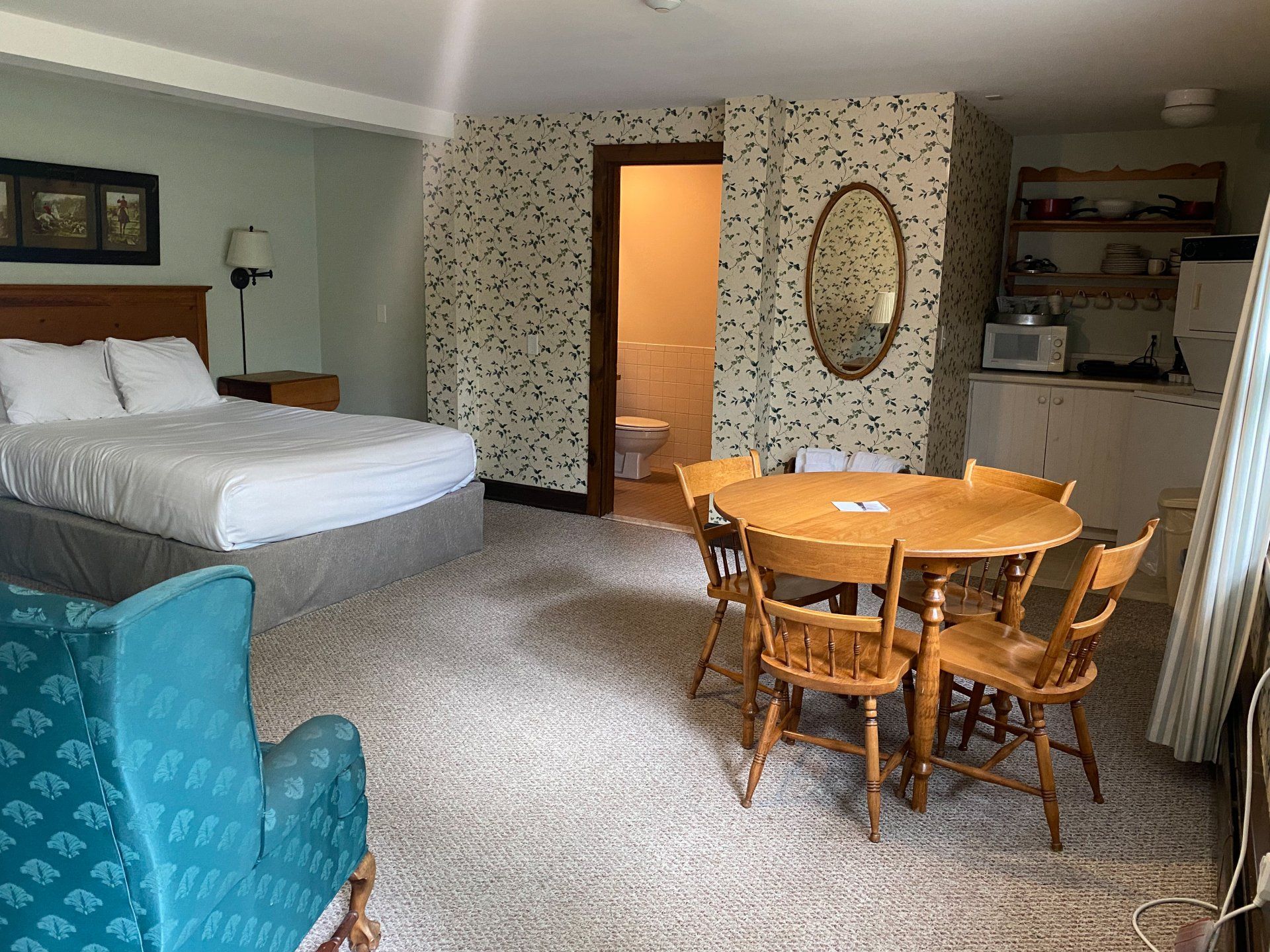 A hotel room with a bed , table and chairs.