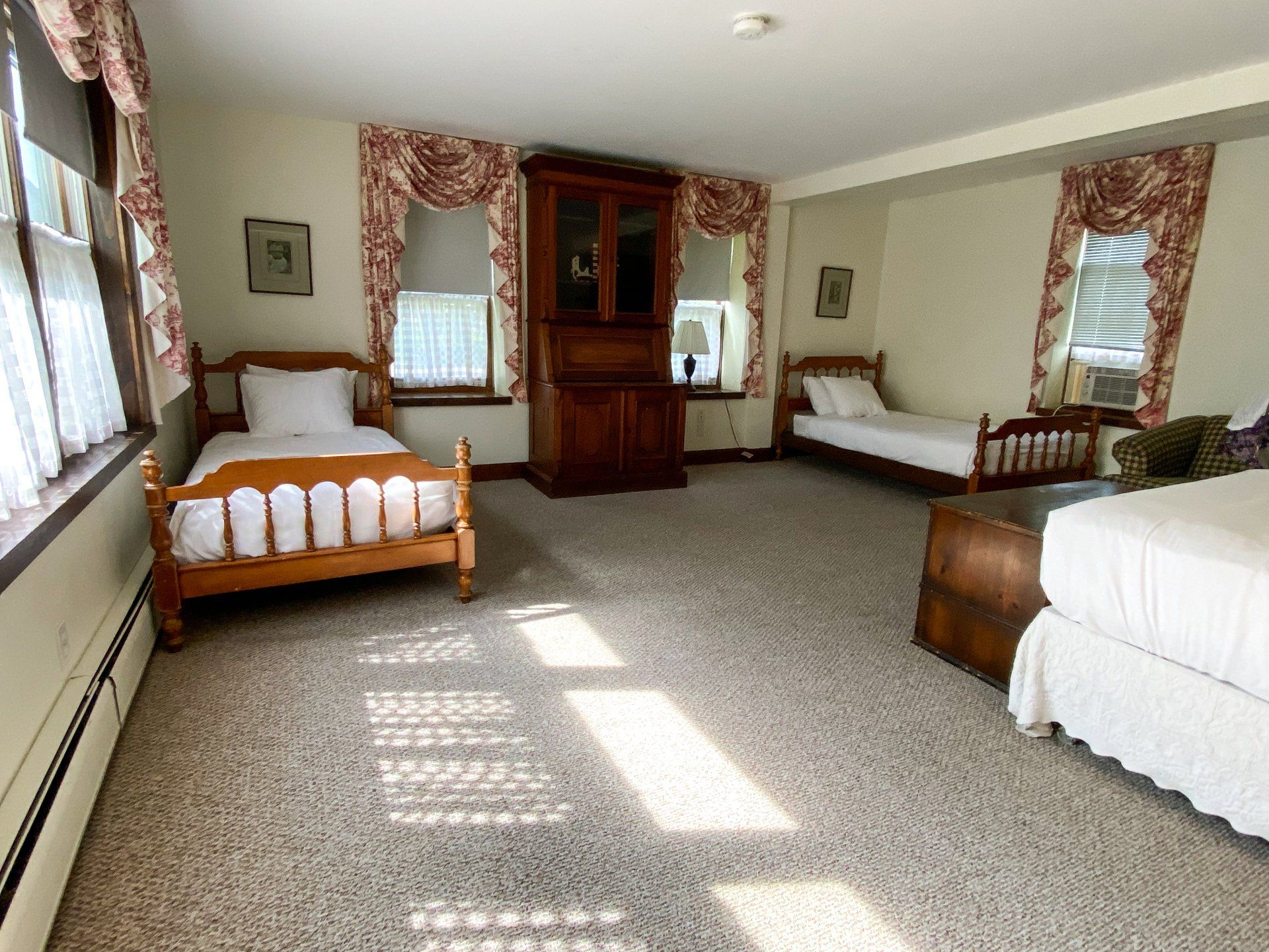 A bedroom with three beds and a dresser