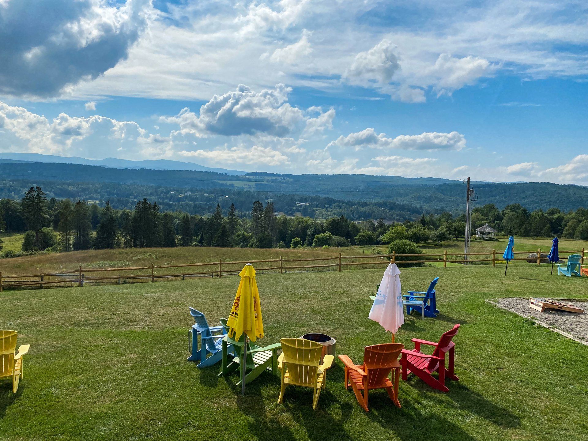 Rainbow adirondack chairs stare out at Burke's hillsides at The Wildflower
