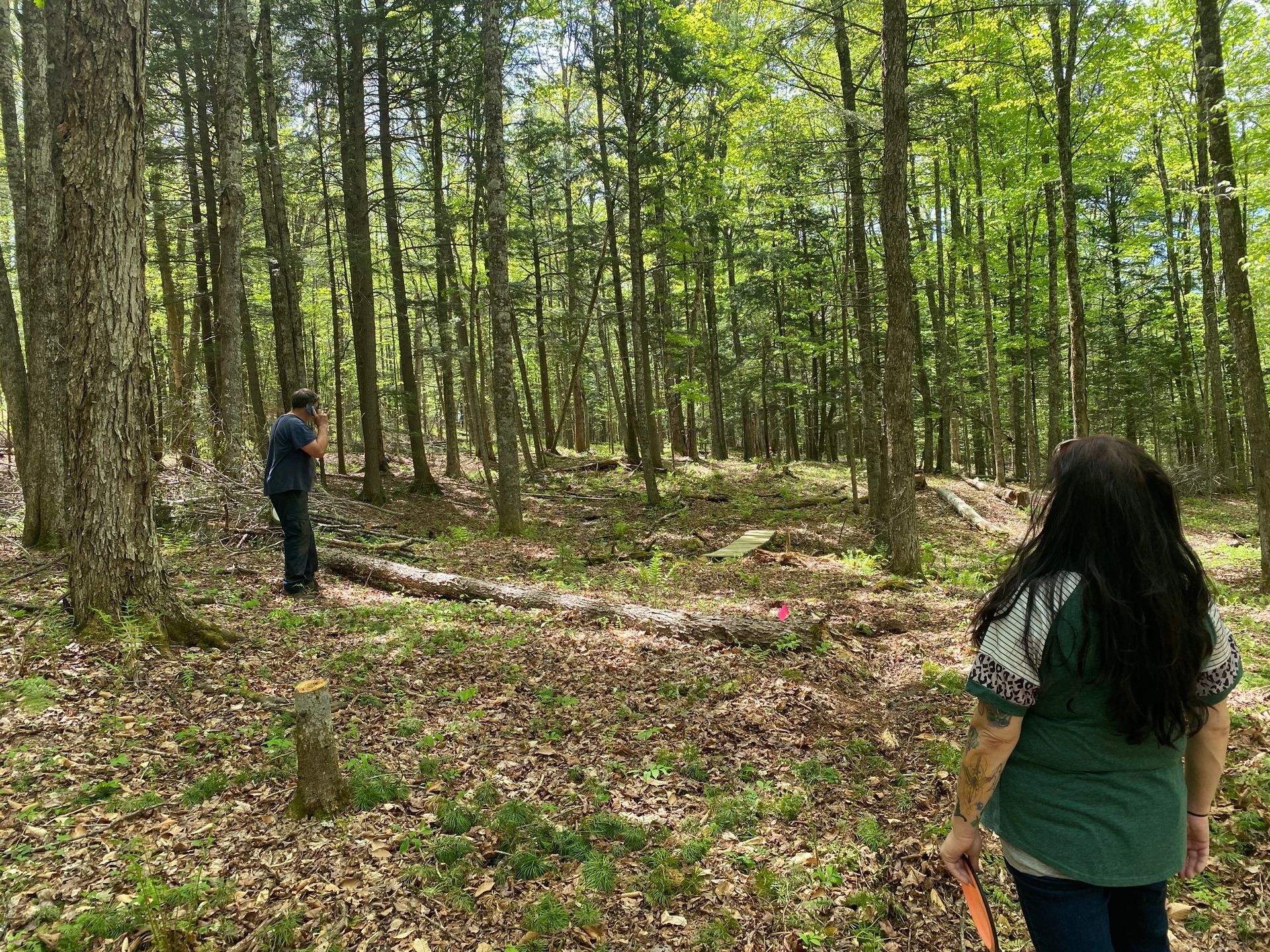 A man and a woman are playing disc golf at the new course at the Wildflower Inn in Northern, VT.