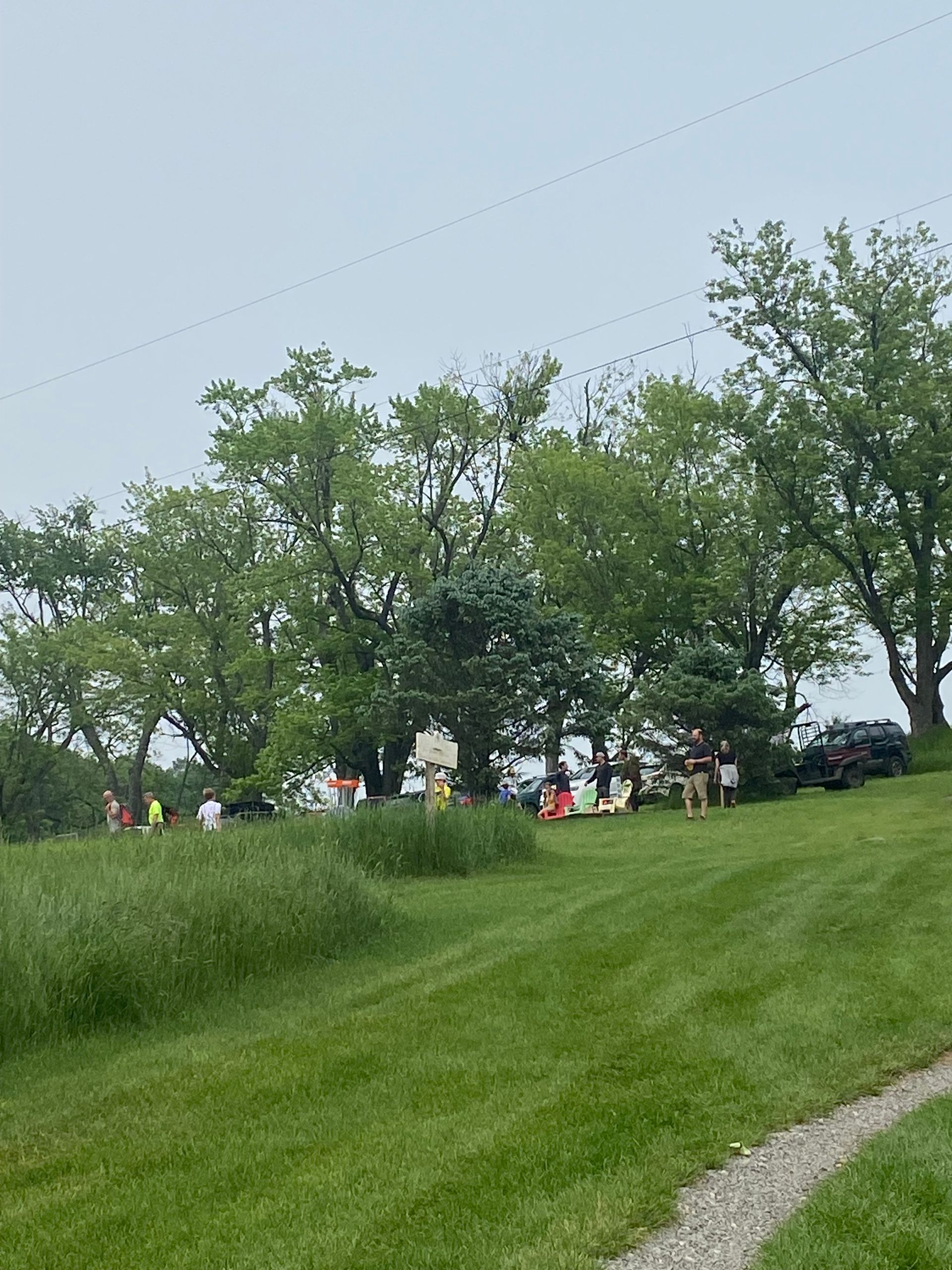 A group of people are standing on top of a grassy hill at the Wildflower Inn in VT.